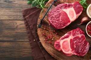 Osso Buco raw steak meat. Barbecue meat. Raw fresh cross cut veal shank and seasonings pepper, rosemary, thyme and salt on ol