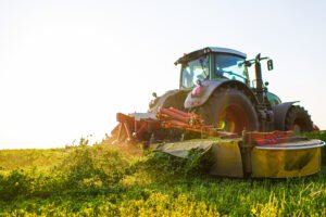 tractor makes harvesting hay for animals on a farm